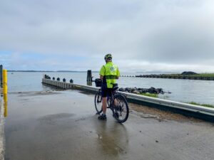 a man on a bike standing next to the water