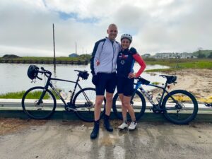 a man and woman standing next to their bikes