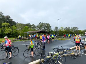 a group of bicyclists standing in a parking lot