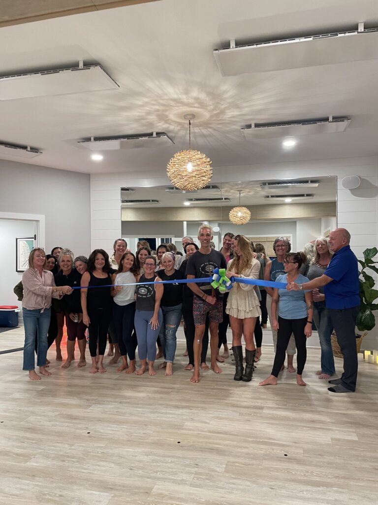 a group of people holding a ribbon in a room