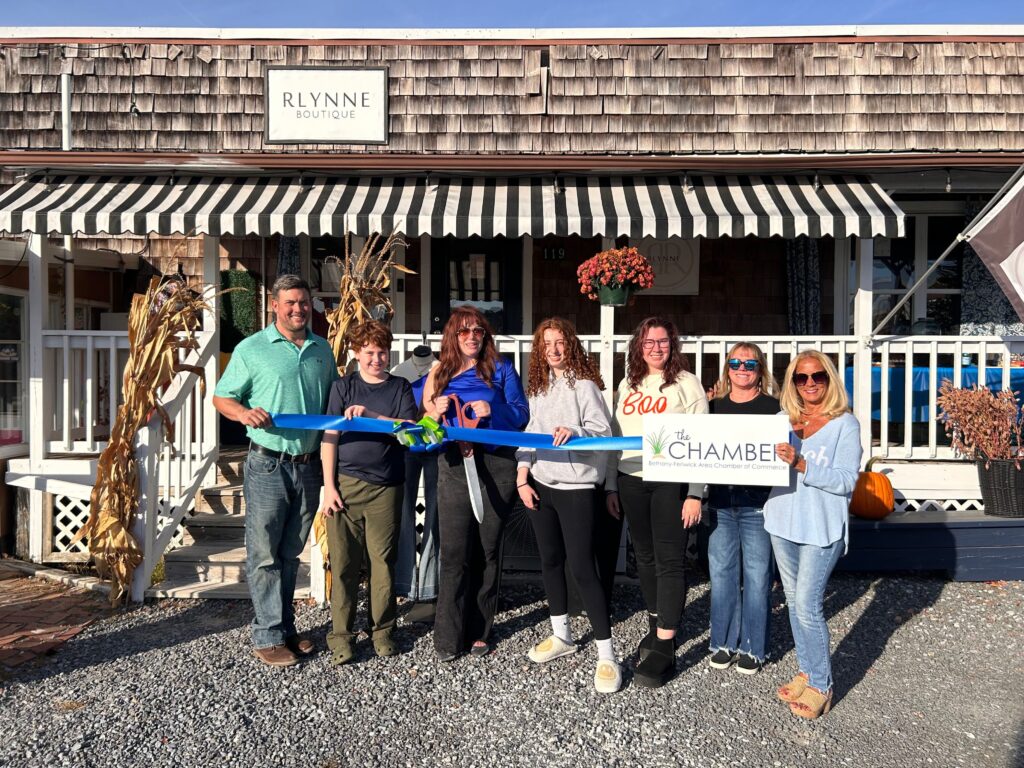 a group of people holding a ribbon in front of a store