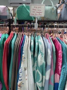 a rack of clothes and handbags in a store