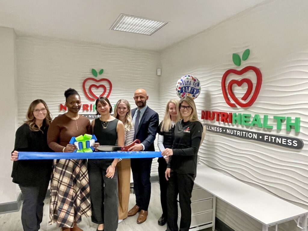 a group of people cutting a ribbon in a room